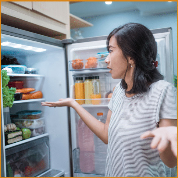 Woman at open fridge door